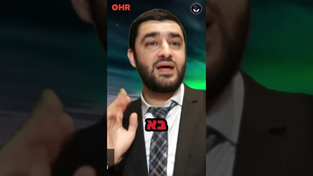 Bearded man in a suit speaking, raising his hand, with OHR logo and Hebrew caption 'יבא' overlayed on a dark aurora background.