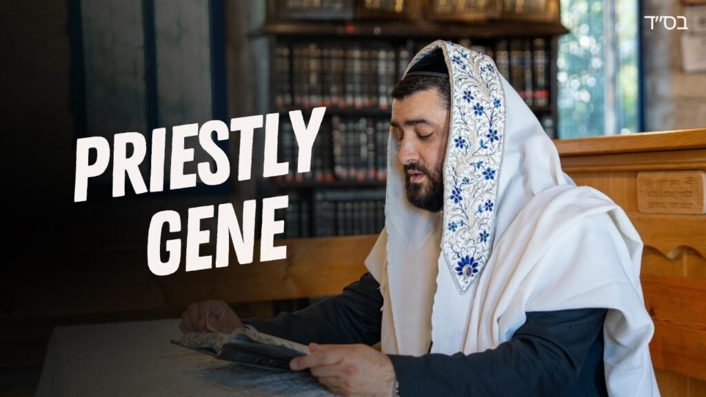 Man wearing a white robe with a blue-embroidered shawl reads a newspaper at a wooden bench in a library-like room.