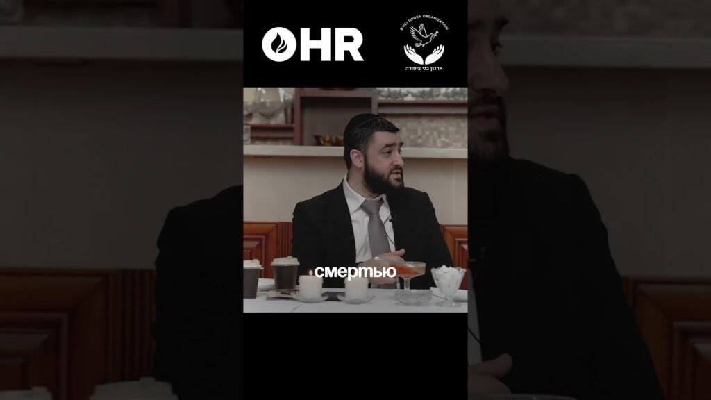 Man in a suit sits at a restaurant table with drinks, while Russian caption 'смертью' appears on screen and OHR logo is at the top.