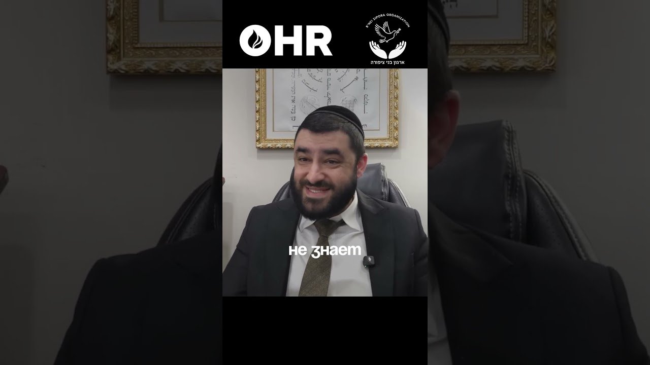 Smiling man in a suit and yarmulke seated in an office; OHR logo at the top and Cyrillic text 'не знает' overlaying the image.