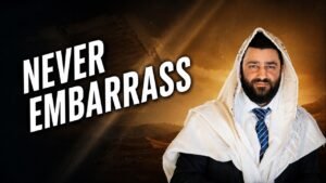 Bearded man in a white headscarf and suit stands beside bold 'NEVER EMBARRASS' text against a desert backdrop.