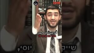 Bearded man in a suit speaking in front of a bookshelf, Hebrew subtitles on screen, OHR logo and another emblem in corners.”,
