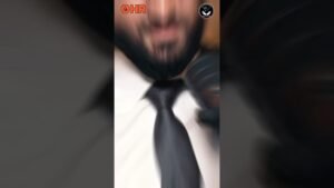 Blurred close-up of a man in a white shirt and black tie, motion blur with orange OHR logo at the upper left and a circular badge at the upper right.